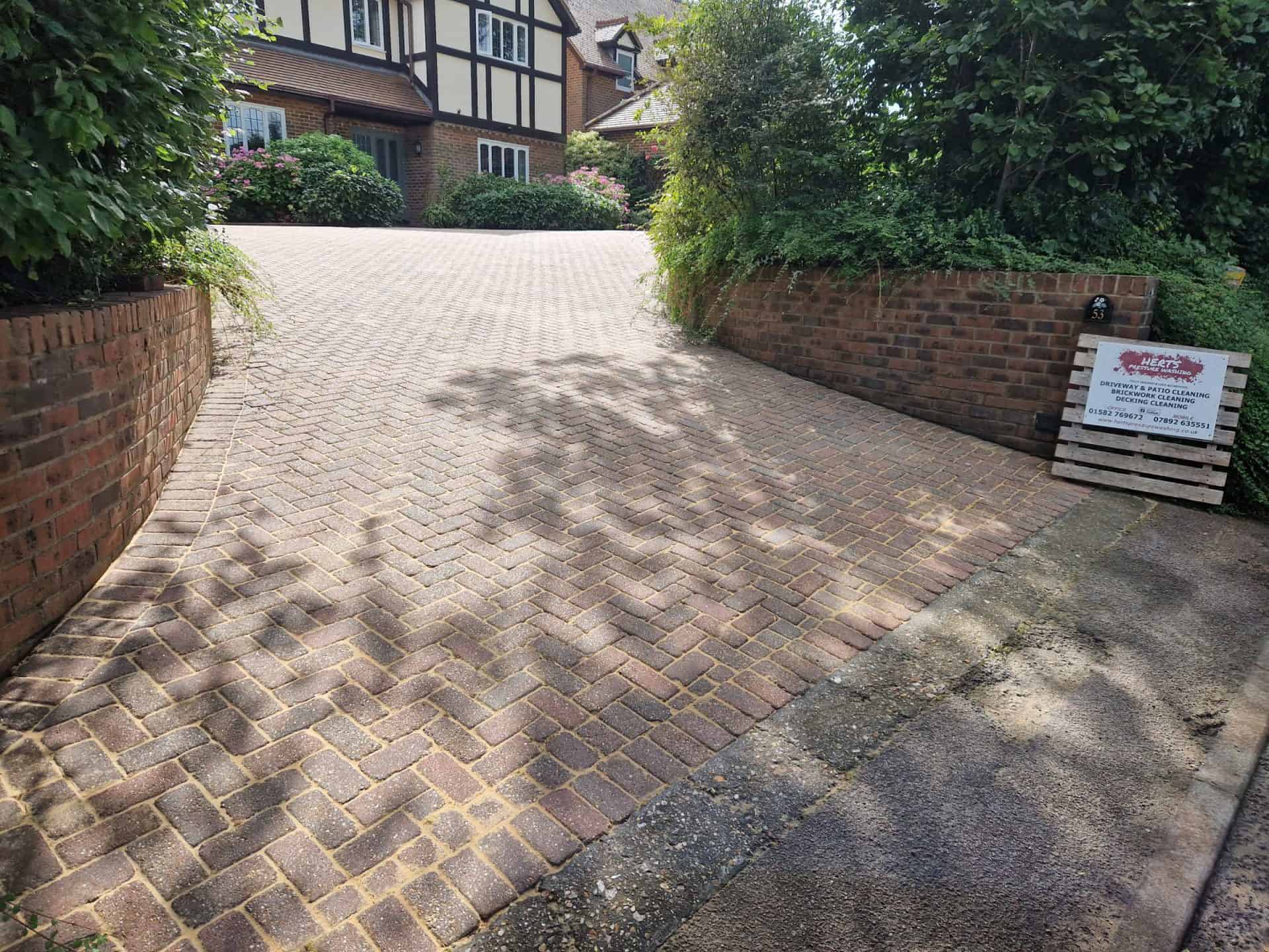 Large block-paved driveway in Hertfordshire after cleaning, with the house behind it