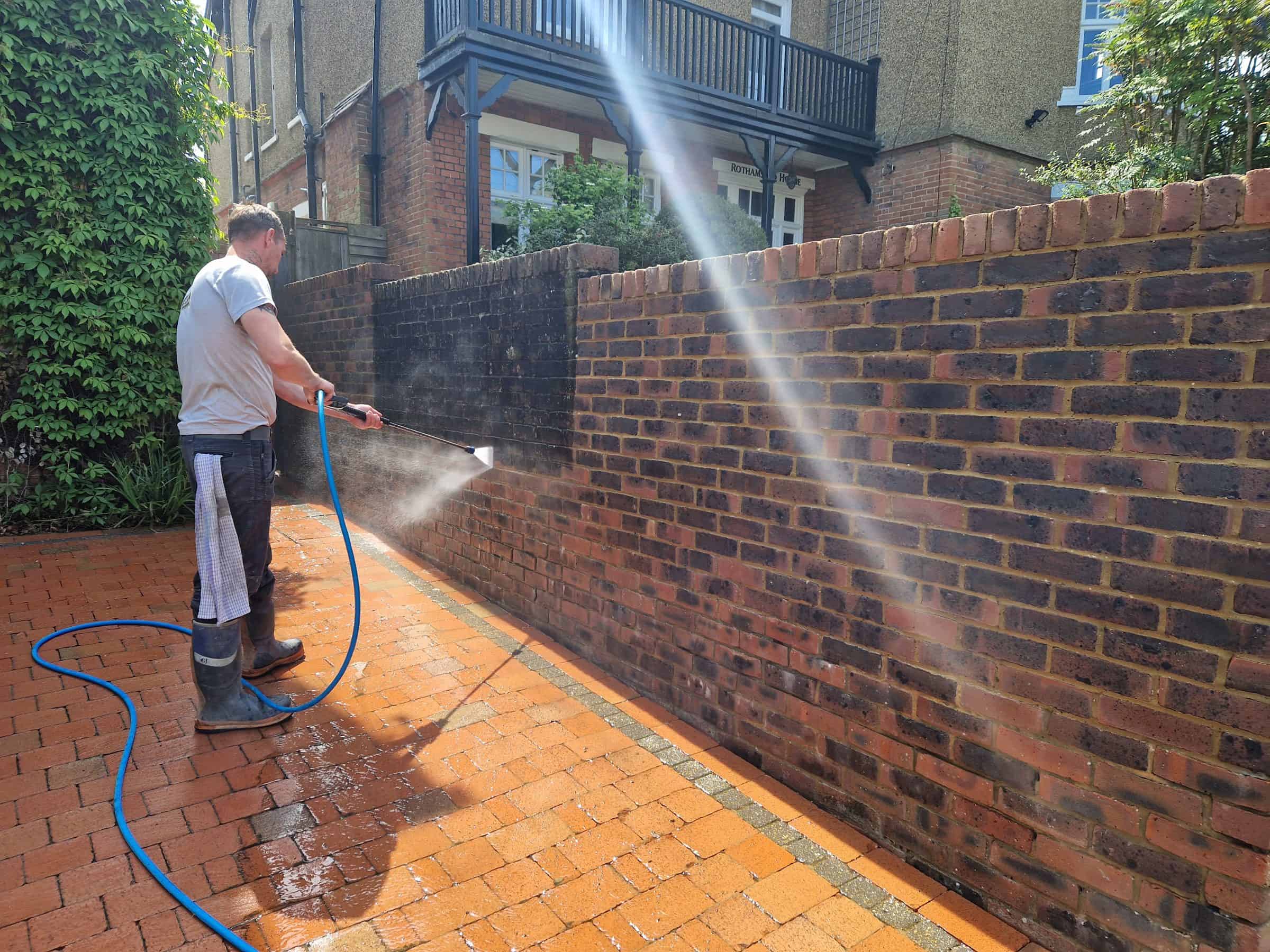 Steam cleaning mould and organic growth off a brick garden wall