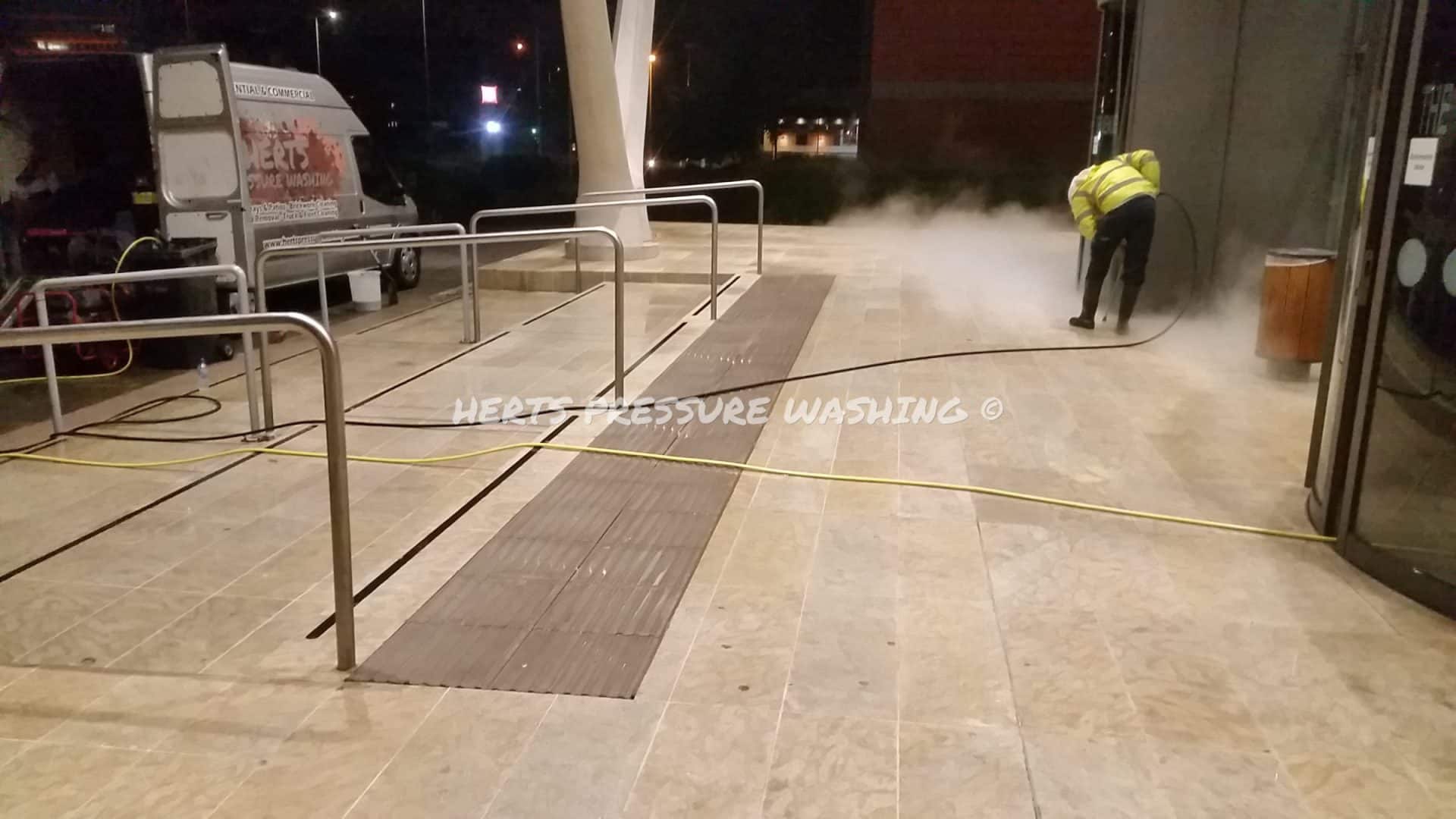 Blackened chewing gum spots on town centre paving before removal
