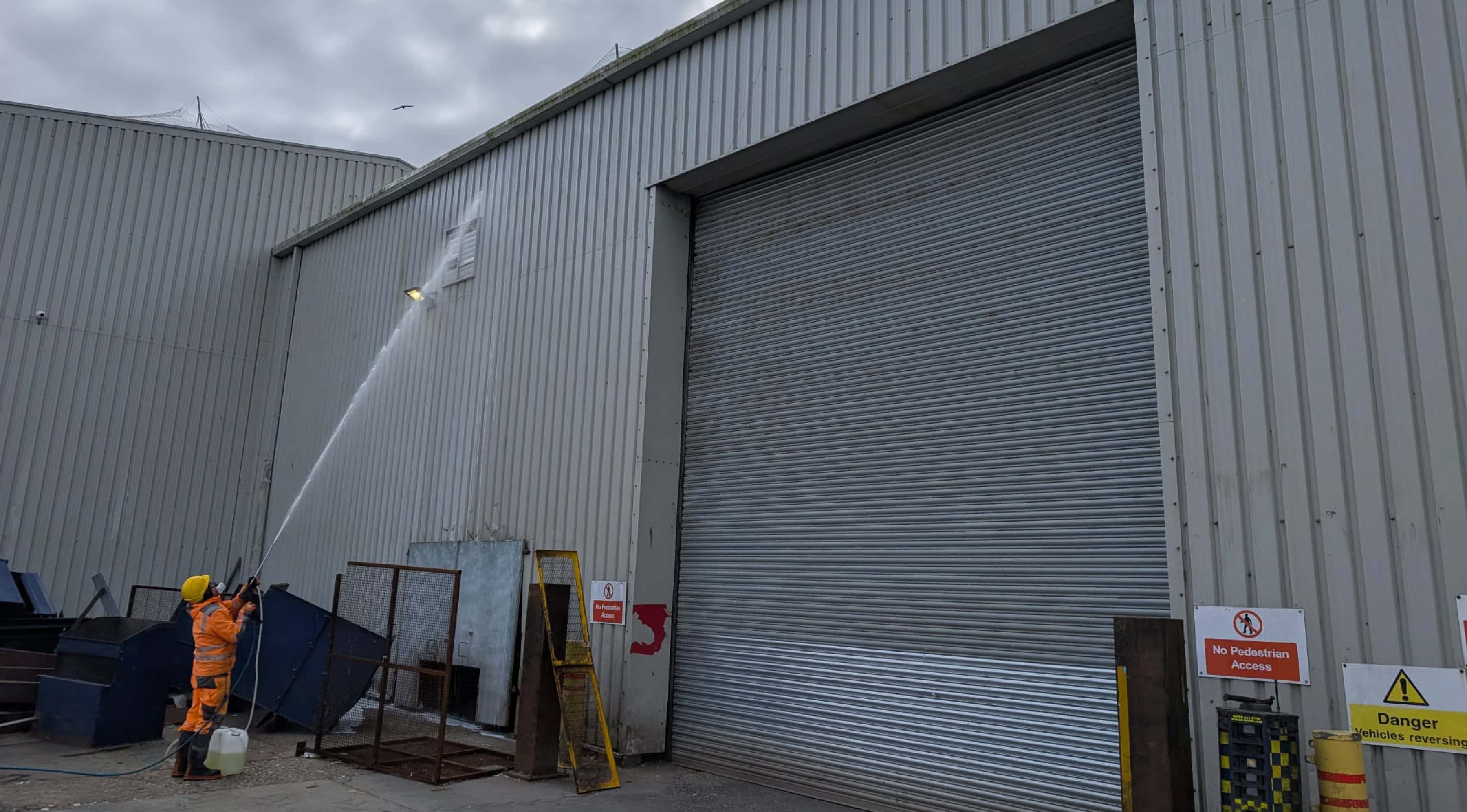 Herts Pressure Washing technician pressure washing the steel cladding on a commercial warehouse