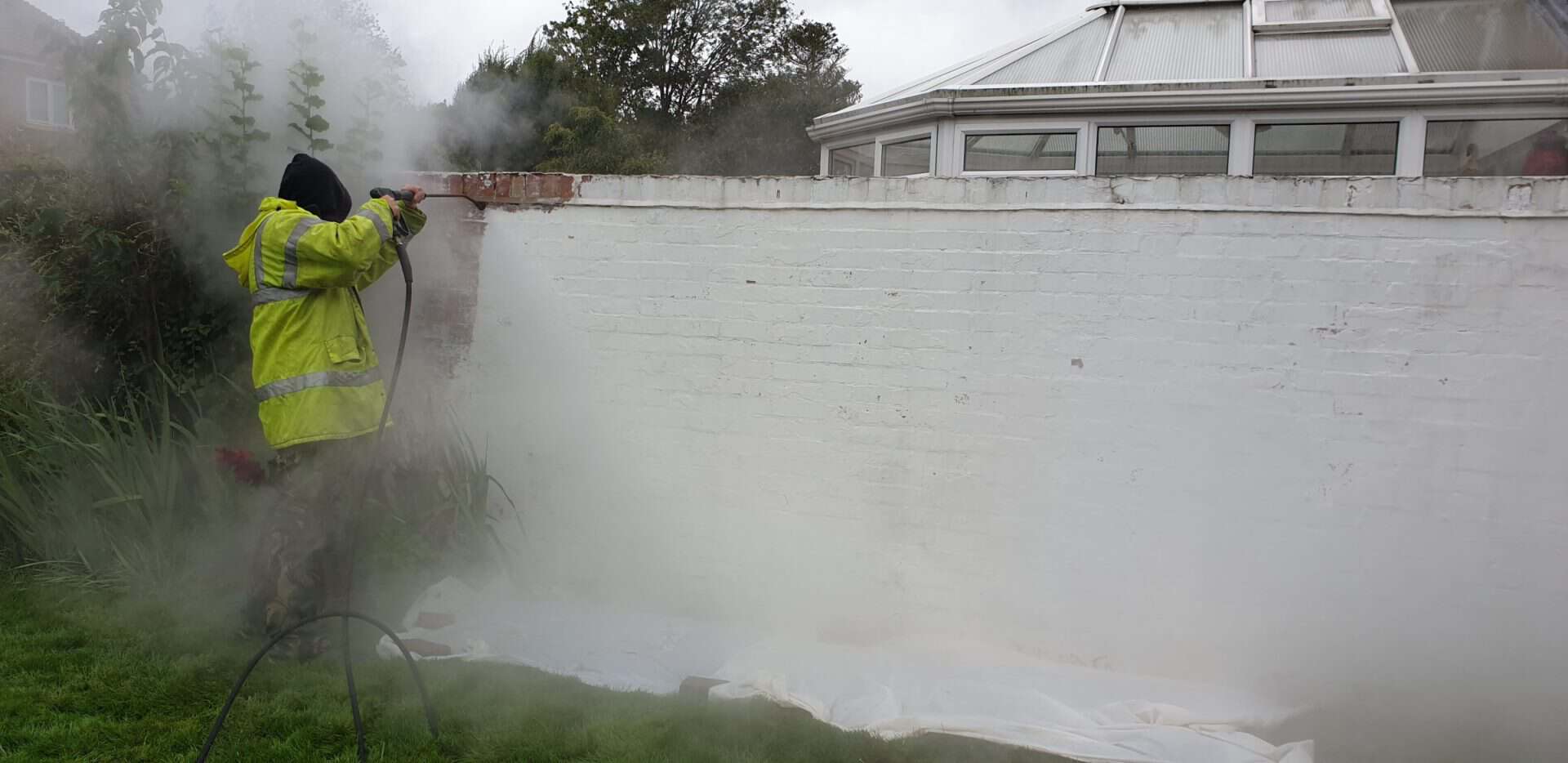 Paint lifting from brickwork under low-pressure steam during a paint removal job