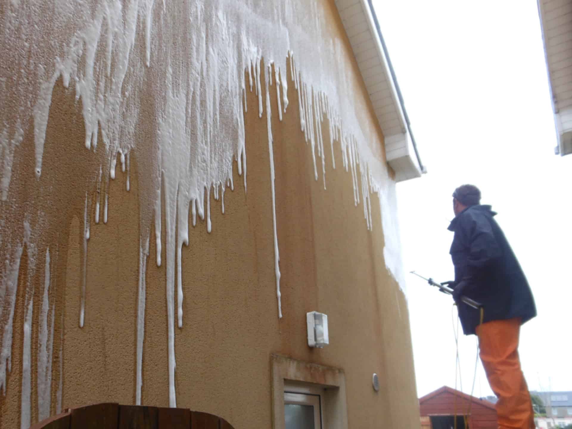 Soft washing a rendered house wall with cleaning foam