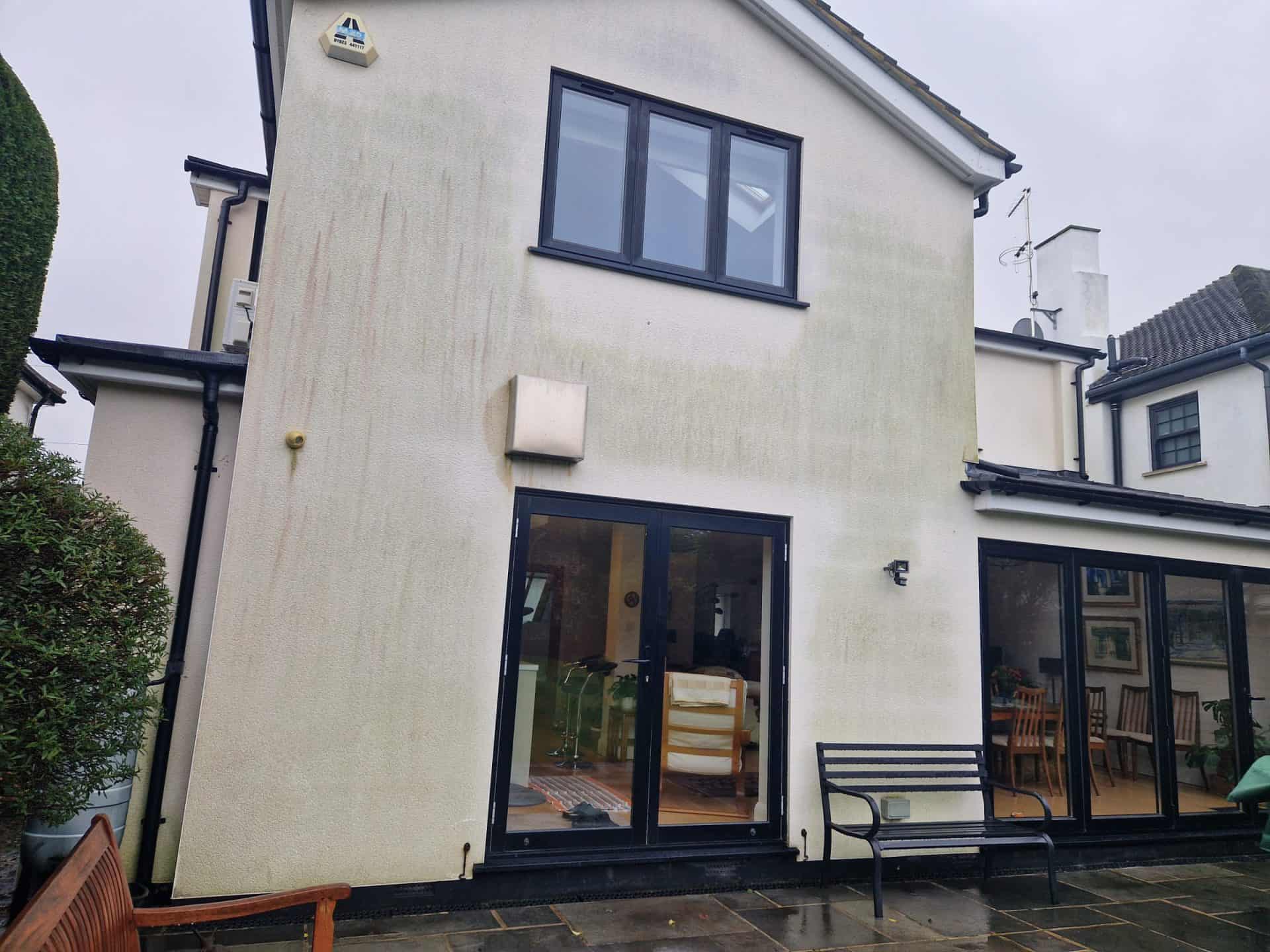Rendered rear extension before cleaning, algae and grey staining across the white render