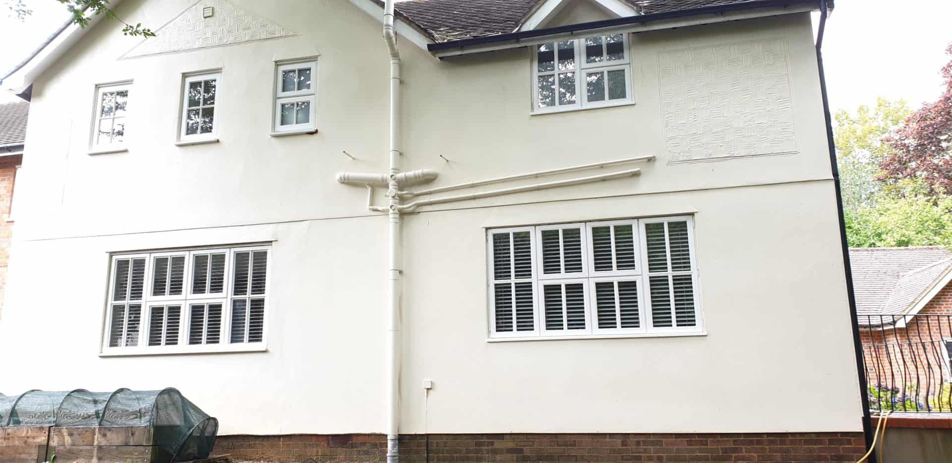 Wide view of the rear of a rendered house after soft washing, render and garden walls cleaned together
