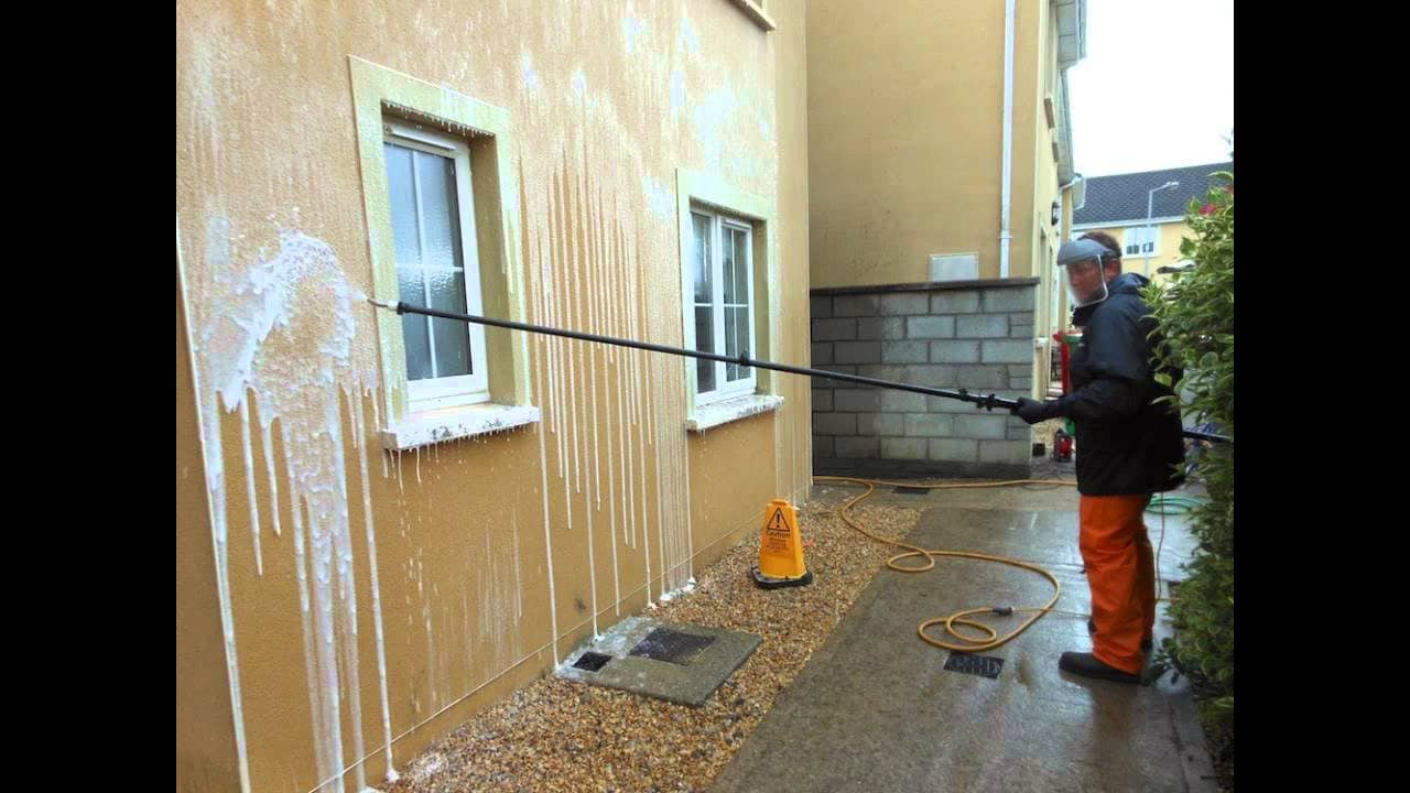 Soft washing in progress, with the biocidal treatment applied to a rendered wall at low pressure
