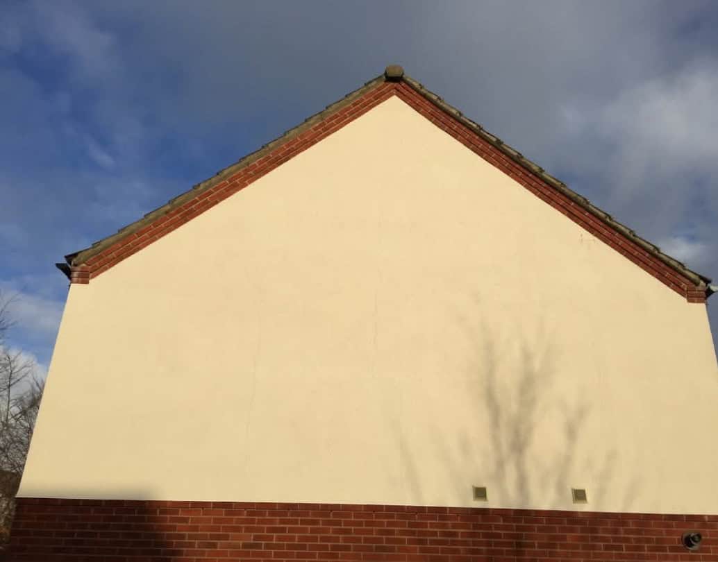 Clean cream render on a house gable end in Hertfordshire after professional render cleaning