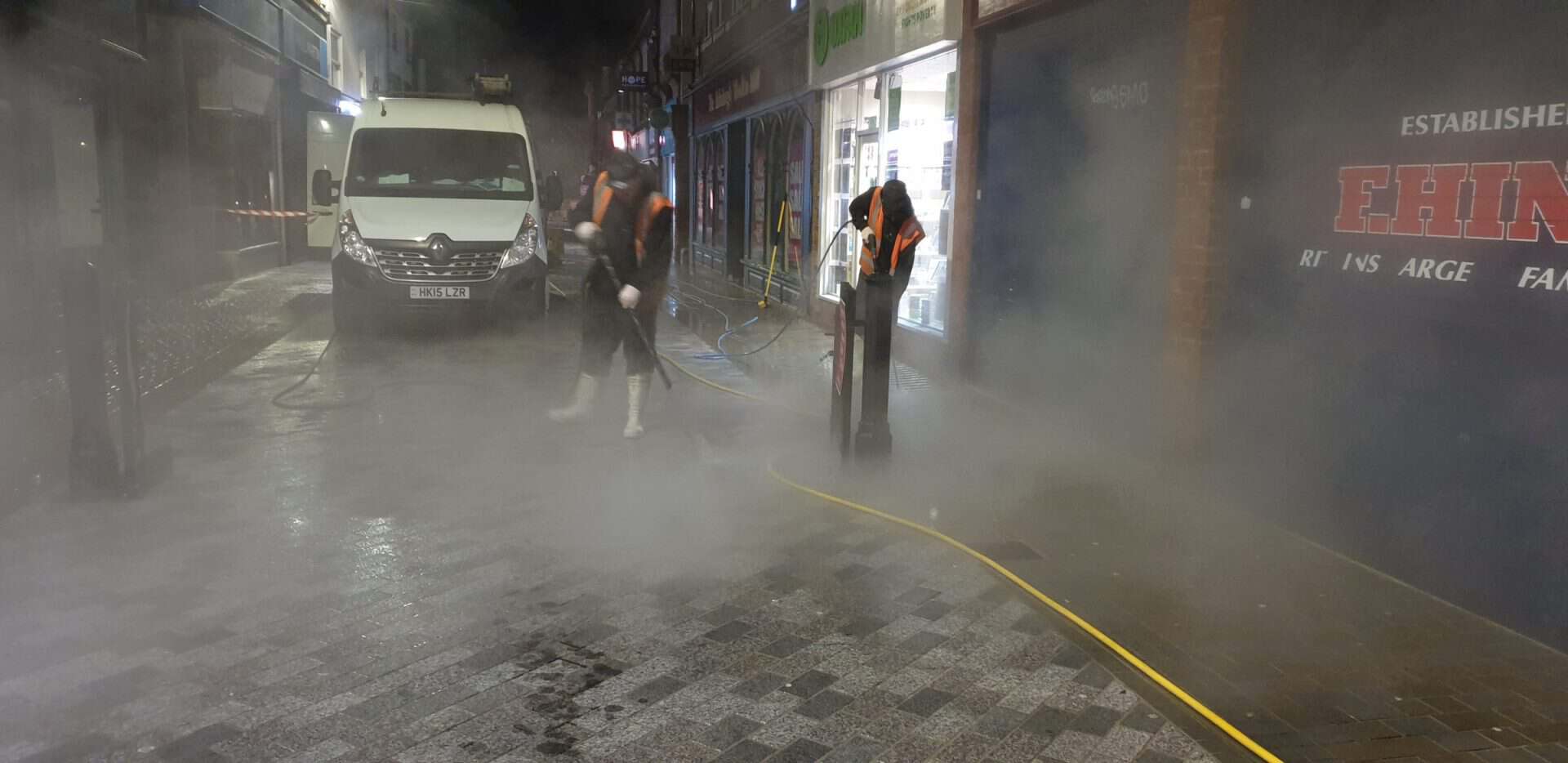 Steam cleaning town centre paving in Hertford at night