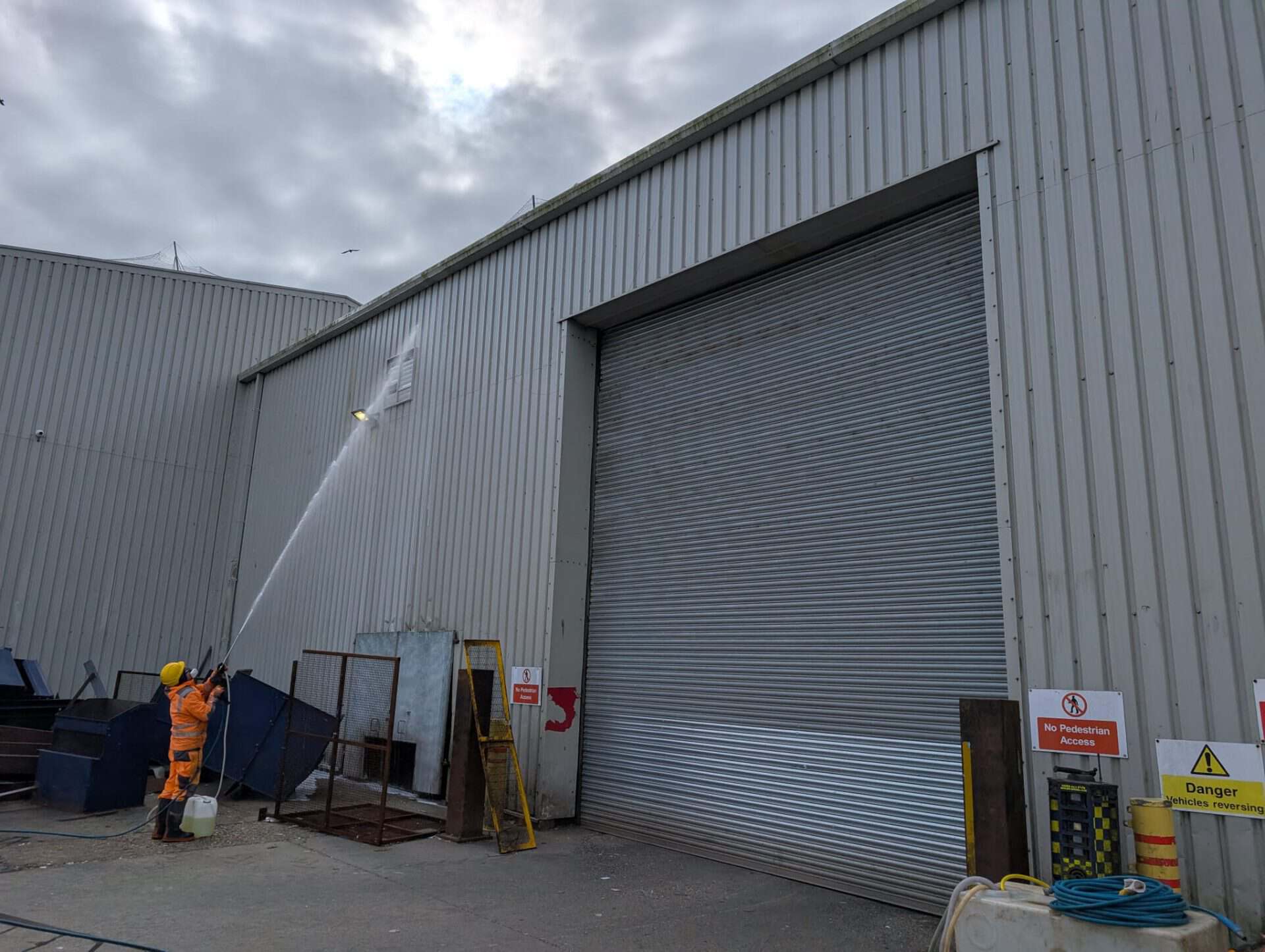 Warehouse loading doors and service yard being pressure washed on an industrial estate